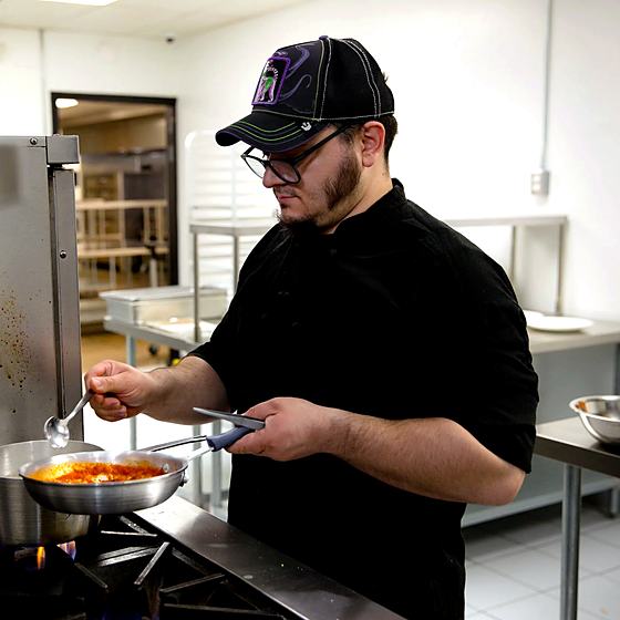 Chef Rich of Kali Vita Fresca cooking at a range in the Frontier Kitchen Pittsburgh kitchen.